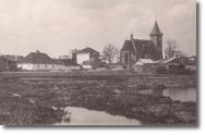 View of Tluste schoolhouse and Roman Catholic church, from across the pond